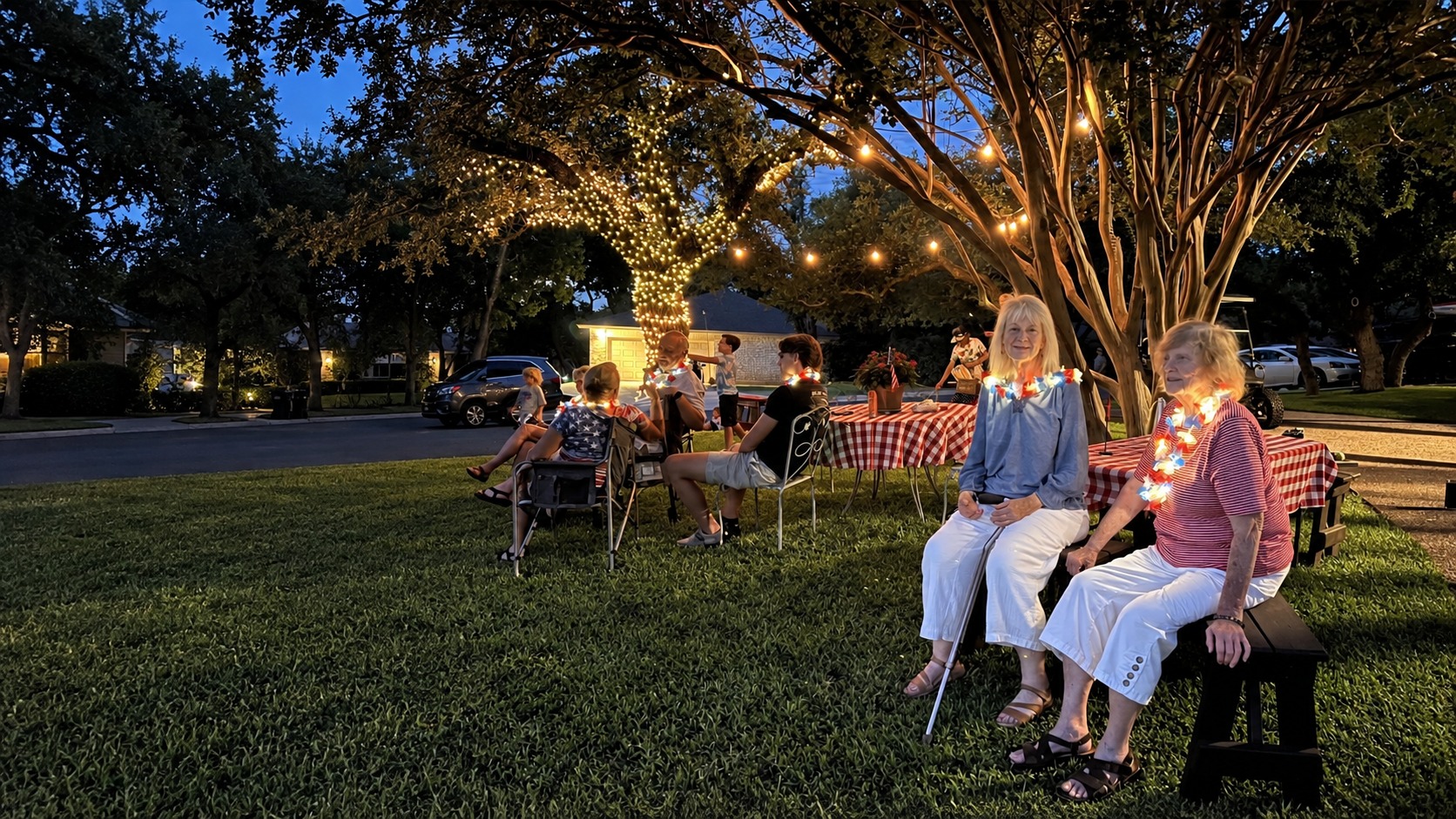 Neighbors gathering casually under warm tree lights in a Georgetown yard at dusk