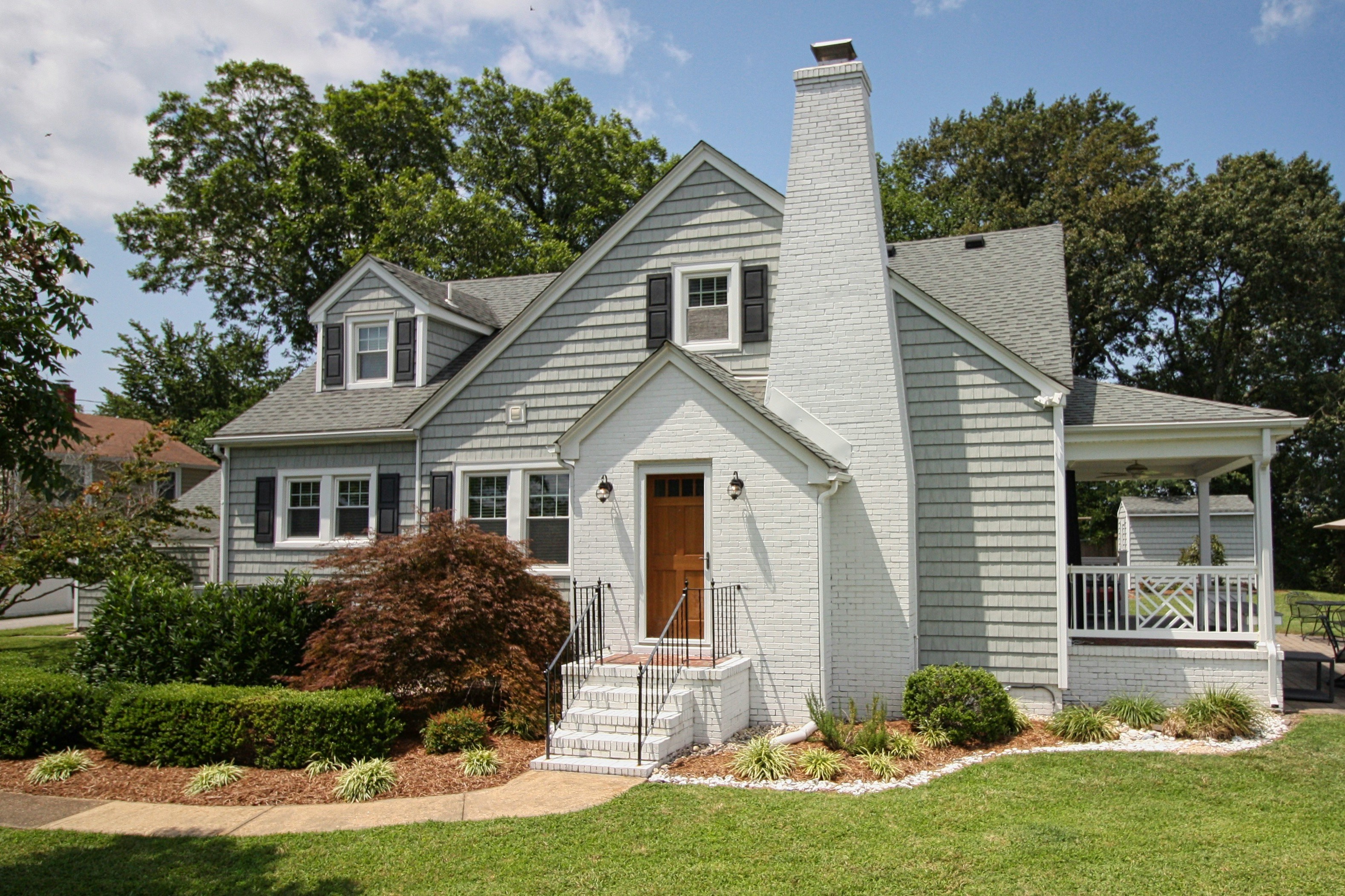 Gray house with a white front porch and lawn