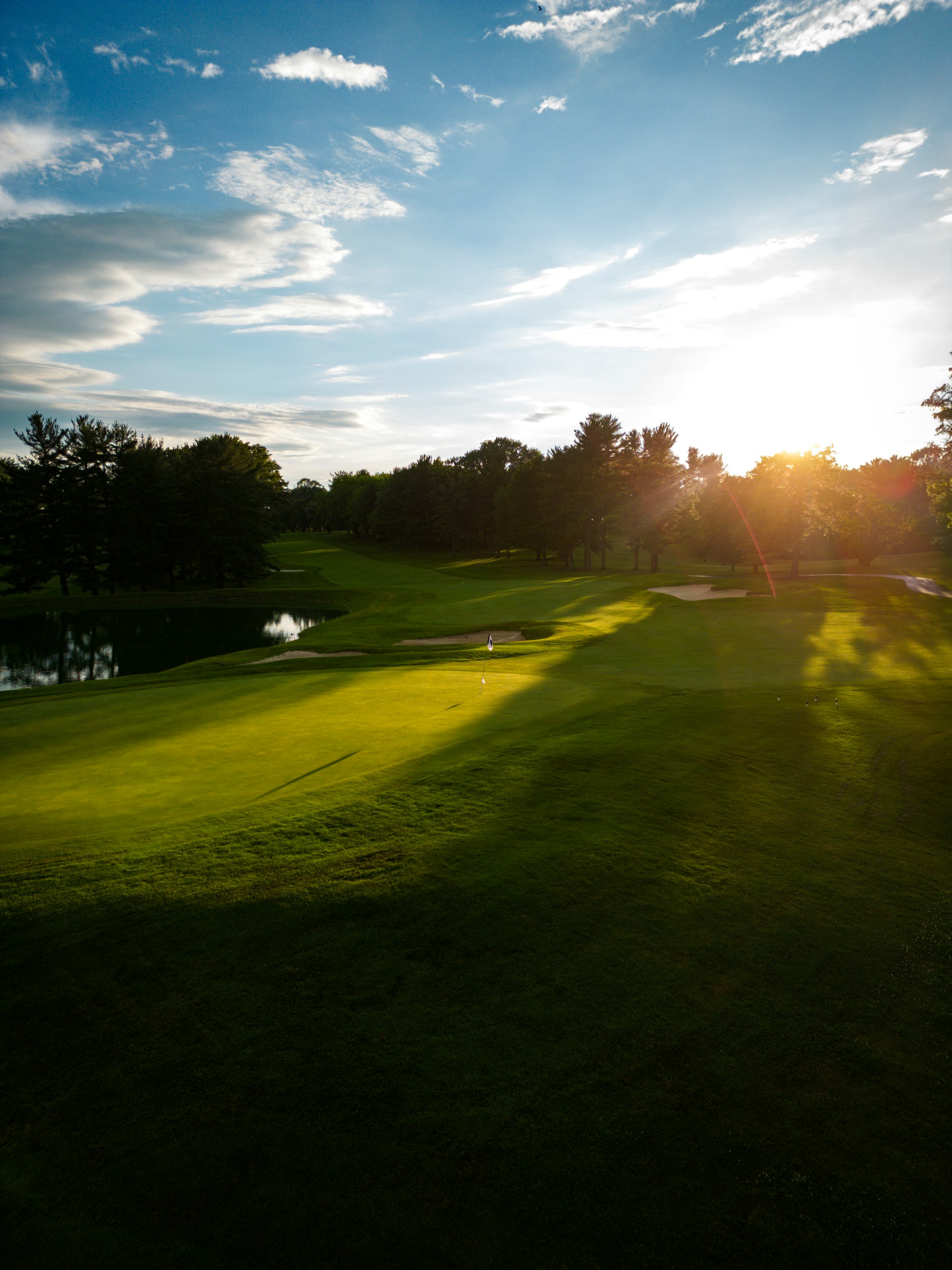 Evening sun shining across a golf course fairway